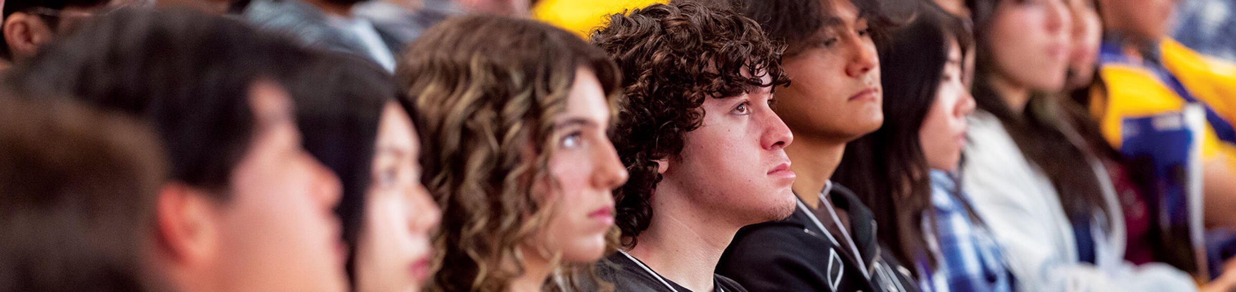 Students seated, looking on during an orientation session.