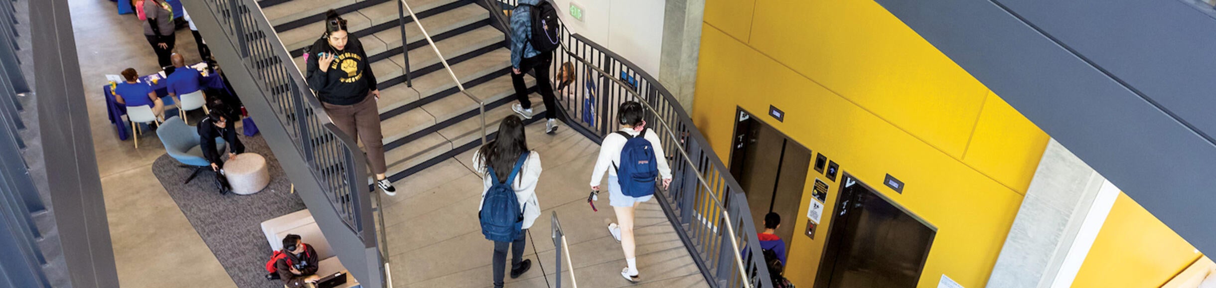 Aerial view of people walking up and down the stairs in thew Student Success Center